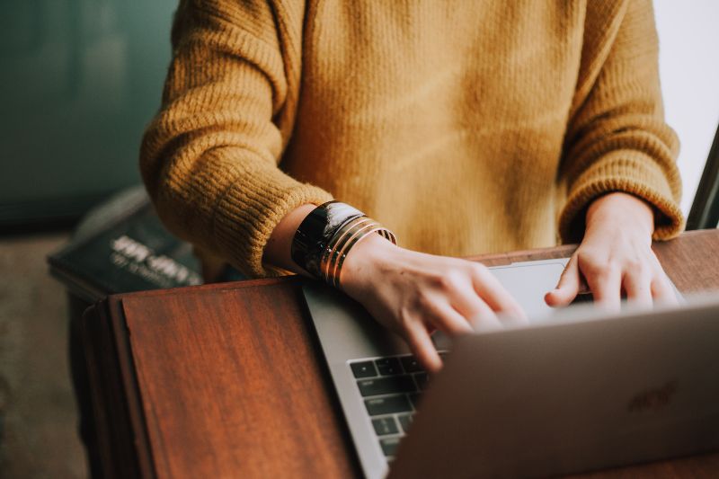 Lady typing on a laptop computer.